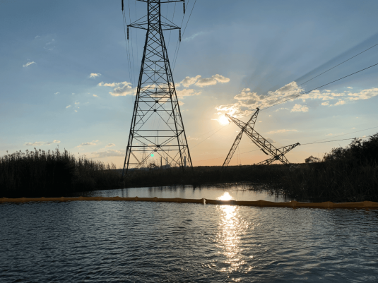 Storm-damaged utility poles and wires after hurricane